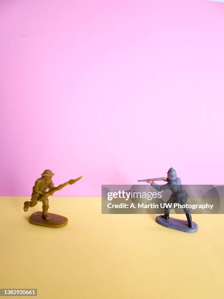 two toy soldiers pointing guns at each other - army soldier toy stock-fotos und bilder