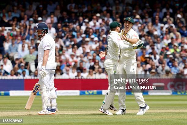 Australia's Pat Cummins and Australia's wicket keeper Alex Carey celebrate taking the wicket of England's Jonny Bairstow for 10 runs on day five of...