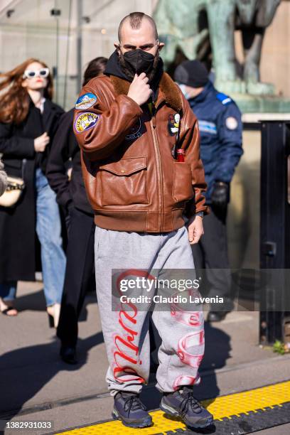 Marc Goehring wearing a brown decorated leather jacket, grey printed sweatpants and blue sneakers, is seen outside Sacai, during Paris Fashion Week -...