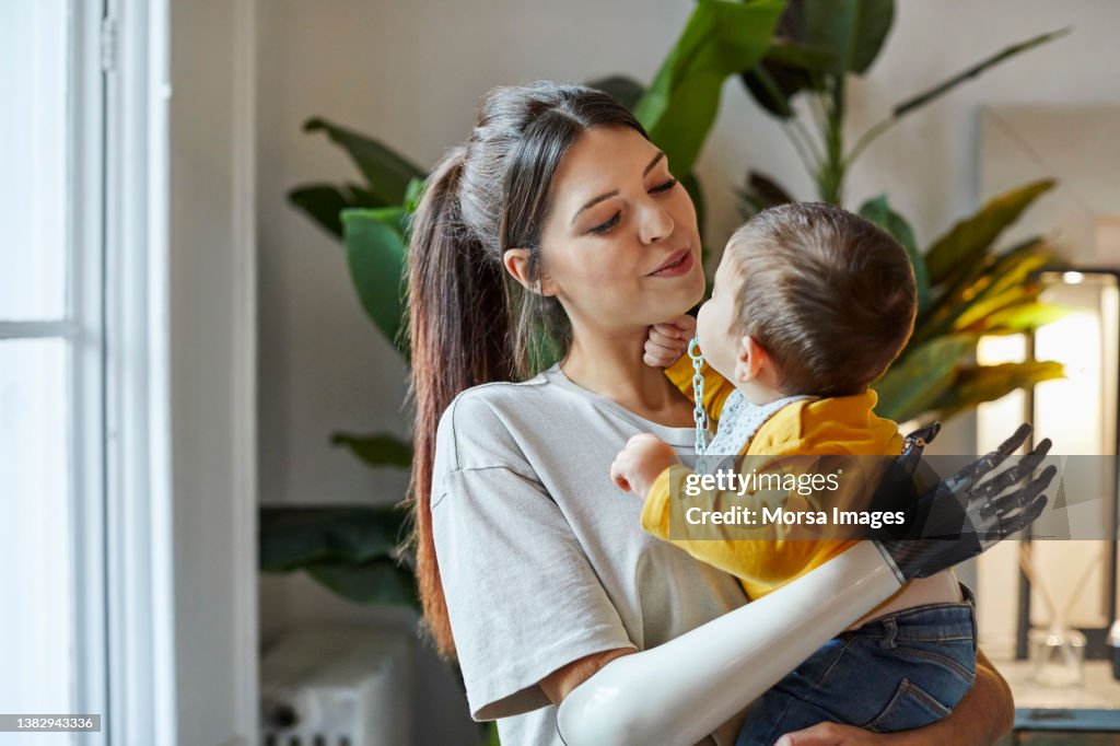 Smiling mother with toddler standing at home