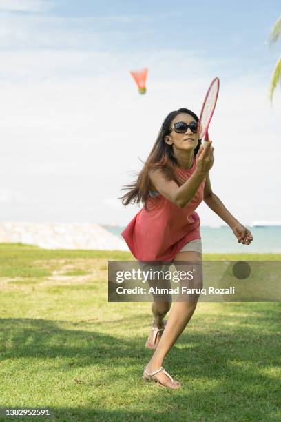 woman playing badminton at the beach - badminton strand stock pictures, royalty-free photos & images