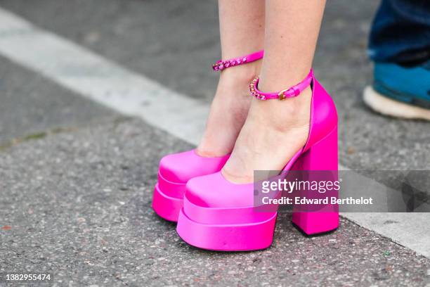 Guest wears neon pink satin Medusa Aevitas platform pumps heels shoes from Versace, outside Giambattista Valli , during Paris Fashion Week -...