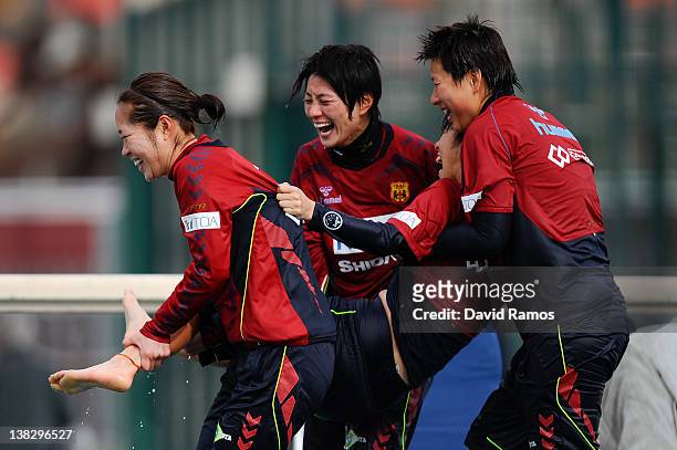 Chiaki Minamiyama of INAC Kobe Leonessa Ladies is thrown into an outdoor swimming pool by her teammates, foloowing a session at the Club Natacion...
