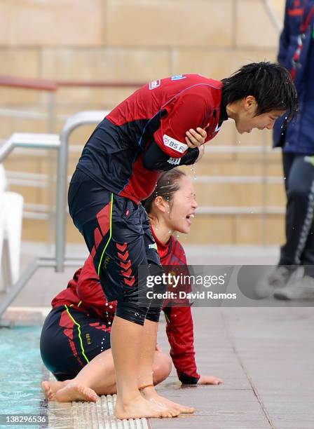 Chiaki Minamiyama of INAC Kobe Leonessa Ladies reacts to the water temperature after being thrown into an outdoor swimming pool by her teammates,...