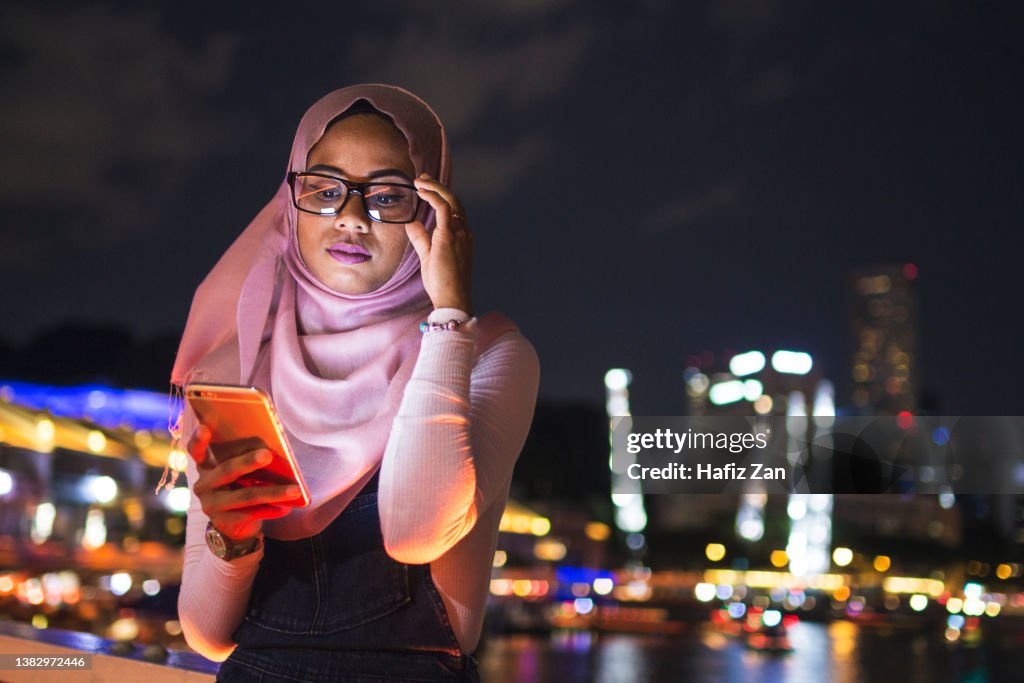 Young Lady Using Her Mobile Phone In The Street Night Light Background ...