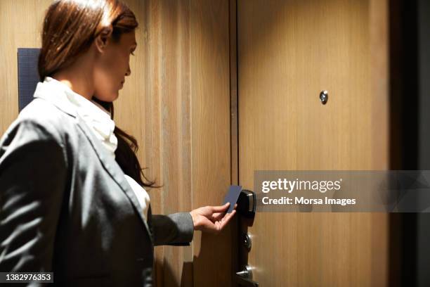 businesswoman unlocking hotel door on arrival - カードキー ストックフォトと画像