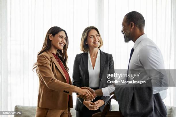 businesswoman shaking hands with coworker in hotel - handshake fotografías e imágenes de stock