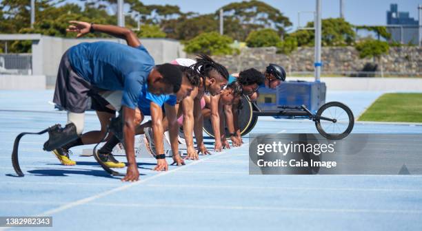 diverse athletes ready at starting line on sunny blue sports track - amputee running stock pictures, royalty-free photos & images