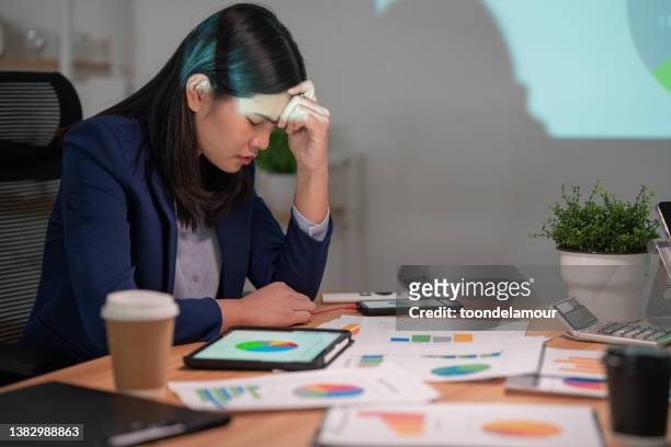 hard-working businesswomen sit stressed at the meeting table in the office. - defeat stockfoto's en -beelden