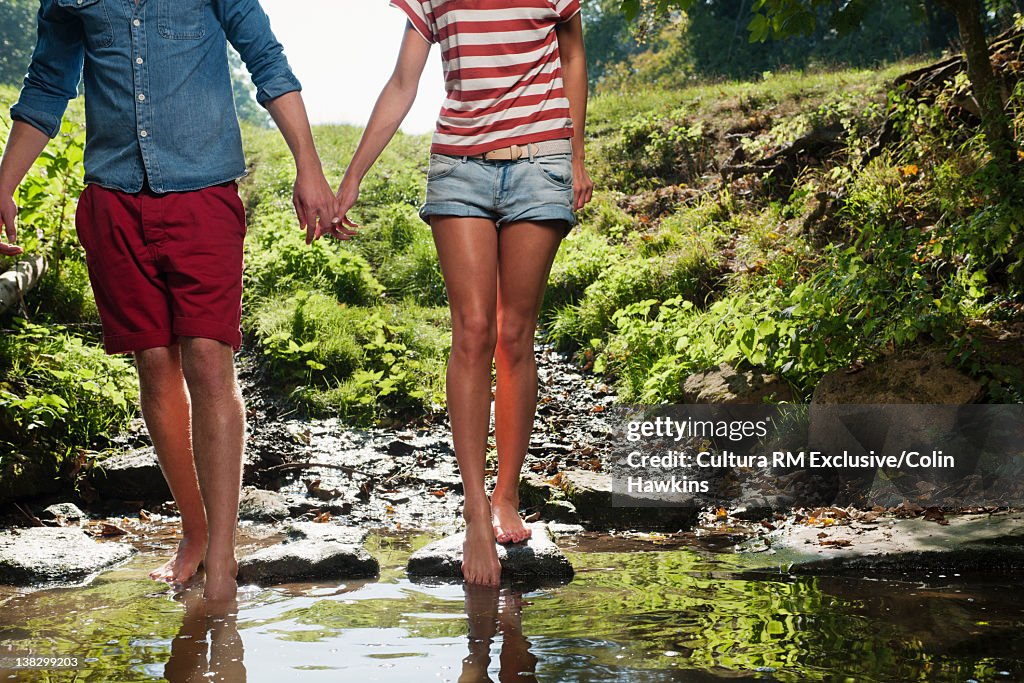 Couple walking in rural creek