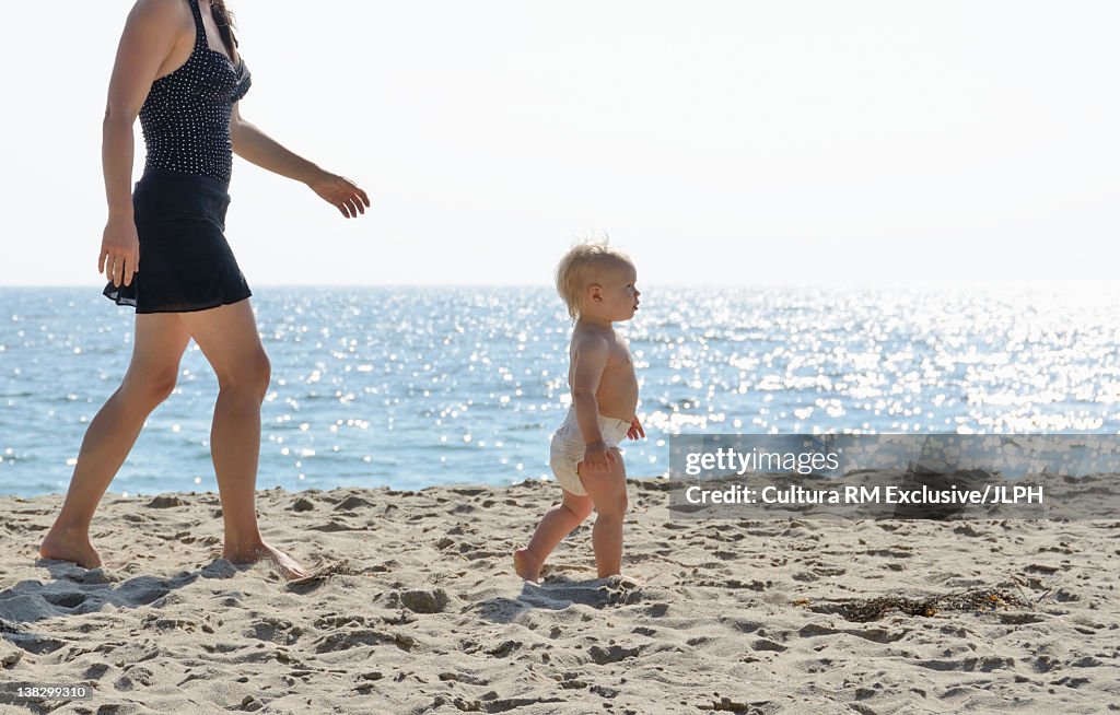 Mother and toddler walking on beach