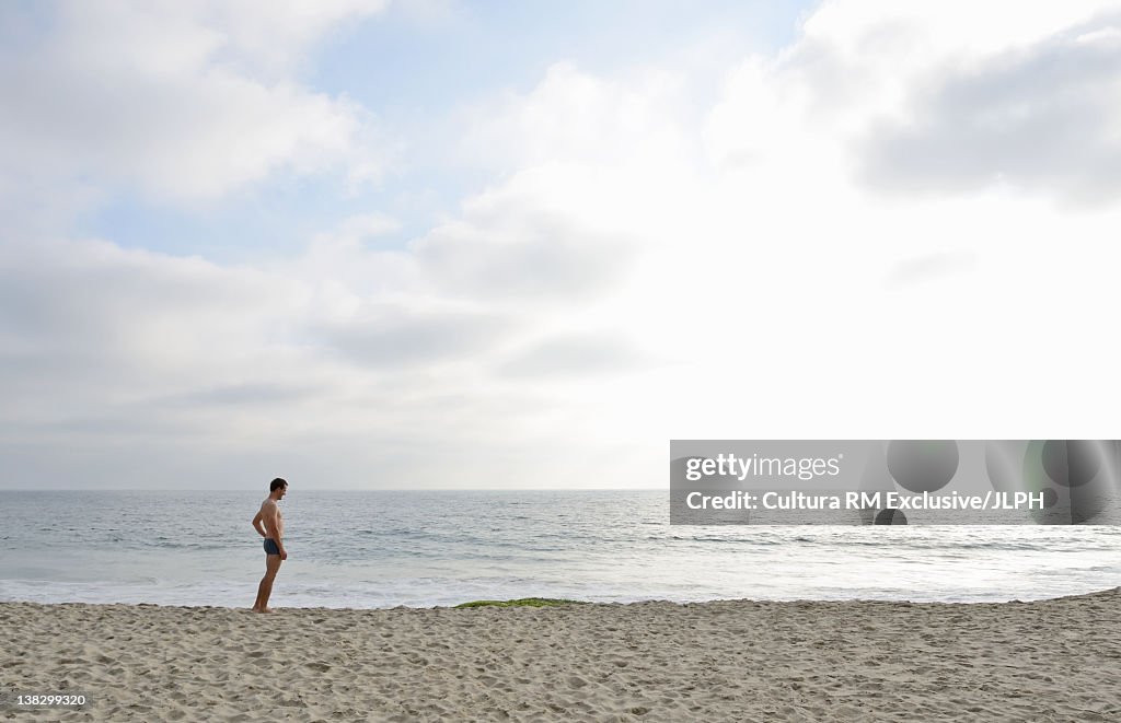 Man standing in waves on beach