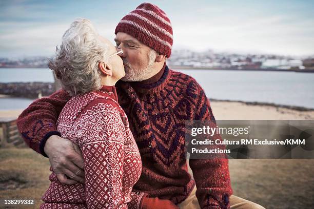 older couple kissing on beach - reykjavik stock pictures, royalty-free photos & images