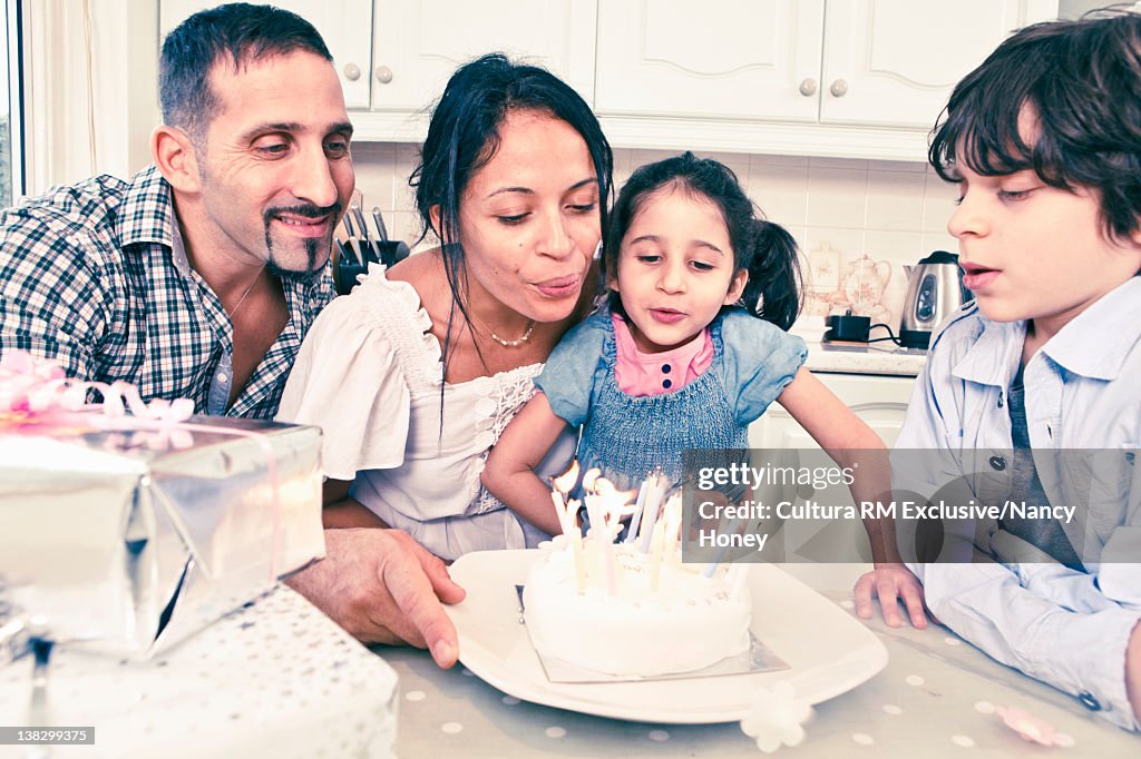 Woman blowing out candles on cake