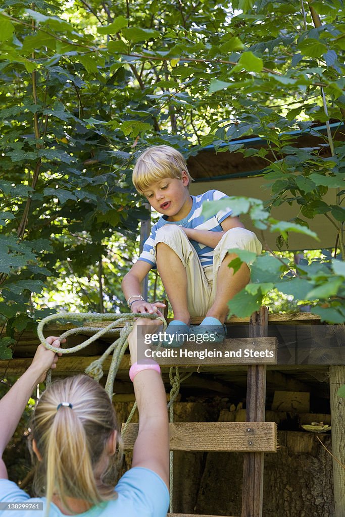 Mãe entregar à corda para filho em treehouse