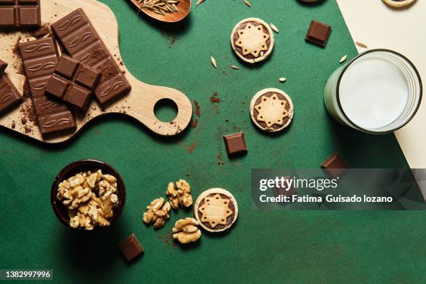 creative still life of walnut cake, biscuits and walnuts on a green and beige background - chocolate cake stock pictures, royalty-free photos & images