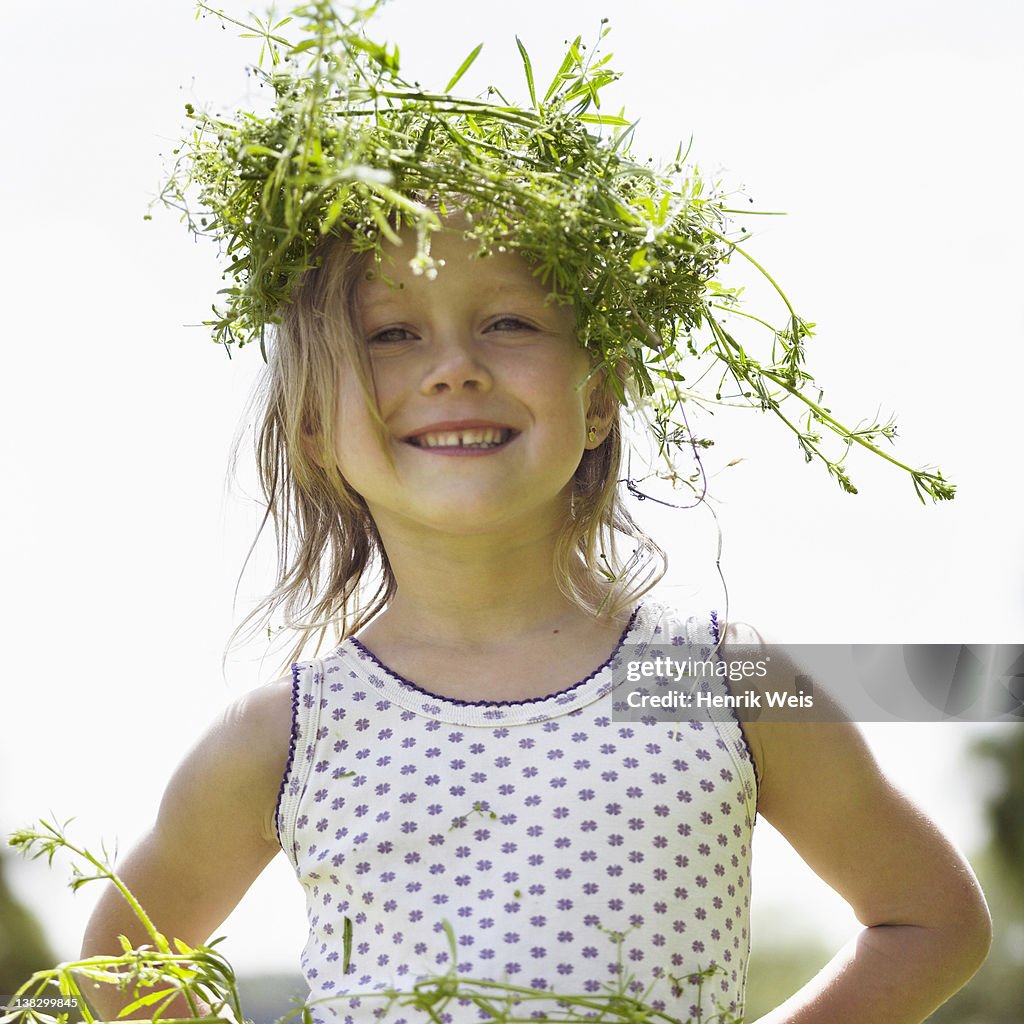 Smiling girl wearing grassy crown