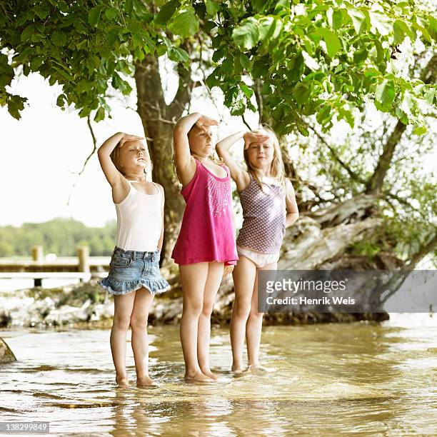 smiling girls playing in lake - child saluting stock pictures, royalty-free photos & images