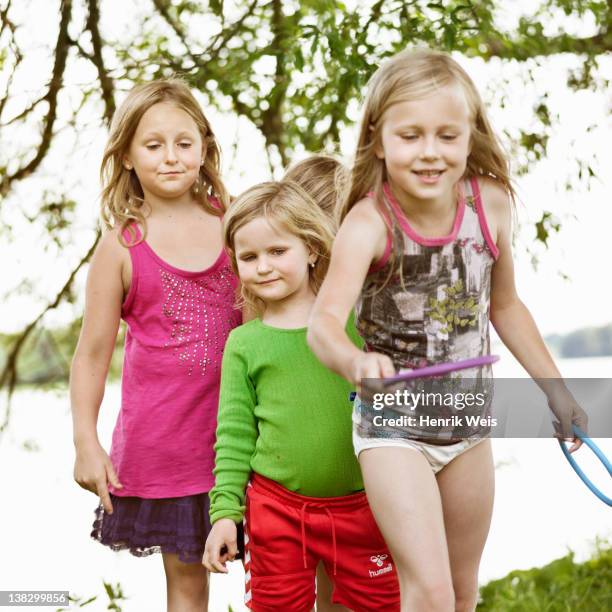 mädchen spielen mit ringen zusammen - mittleres kindesalter stock-fotos und bilder