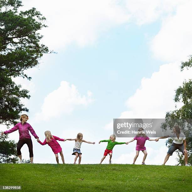 girls playing tug-of-war in field - dust bildbanksfoton och bilder