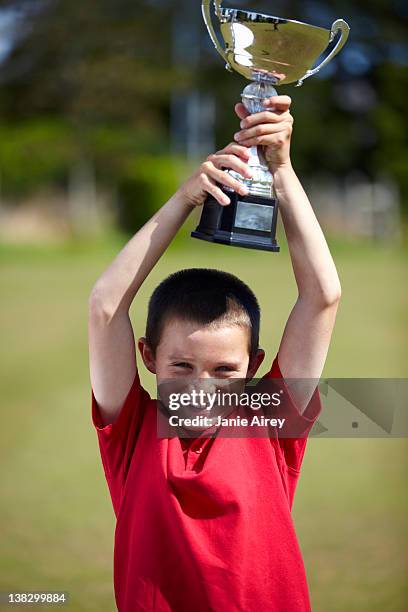 menino a celebrar com troféu ao ar livre - title nine imagens e fotografias de stock