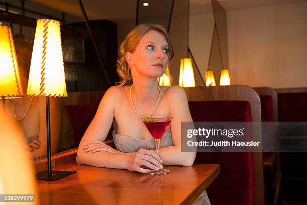 woman having drink at restaurant - evening gown photos et images de collection