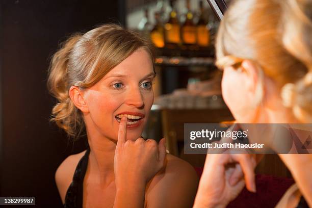 woman checking her teeth in mirror - pick tooth bildbanksfoton och bilder