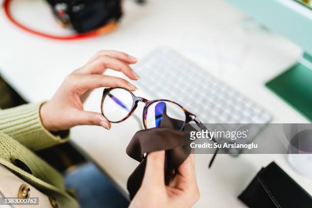 gafas de limpieza a mano femenina irreconocibles en la oficina - aljofifa fotografías e imágenes de stock