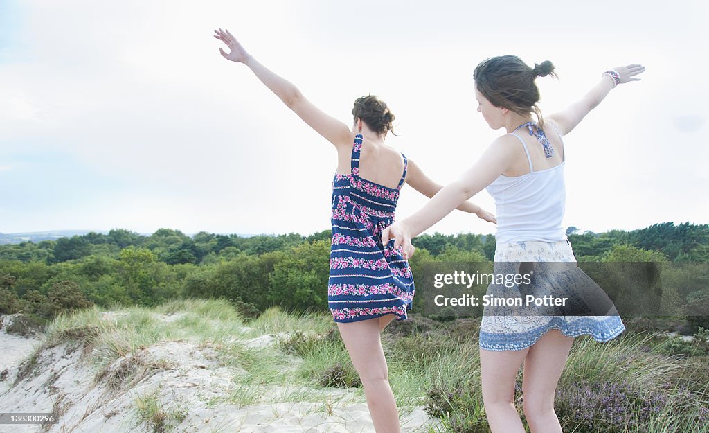 Women playing airplane on beach