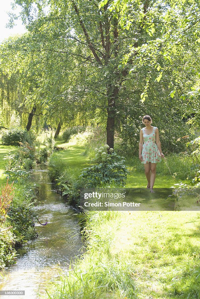 Girl picking flowers by river