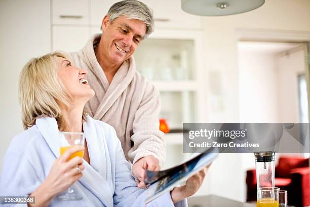 couple reading magazine at breakfast - glass magazine stock pictures, royalty-free photos & images