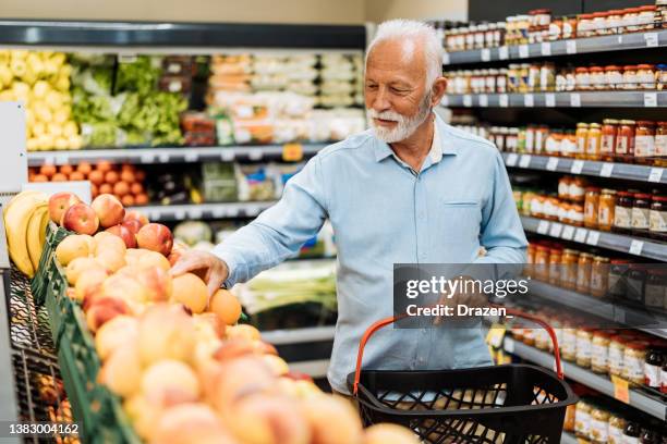 retired man buying groceries - fruits and vegetables - mercearia imagens e fotografias de stock