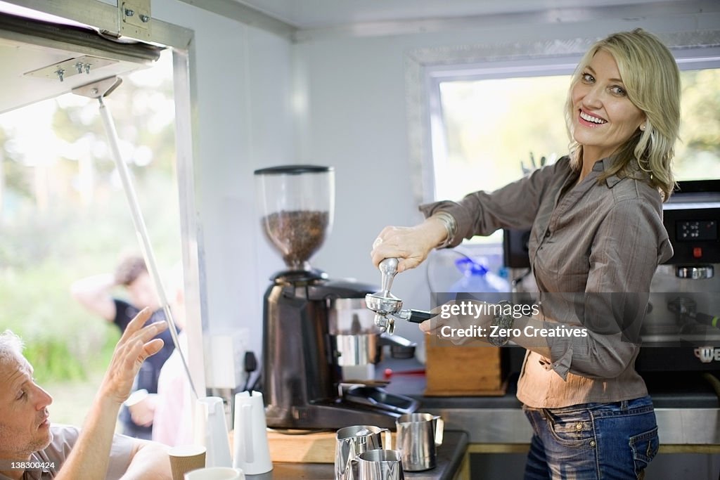 Woman making coffee in food cart
