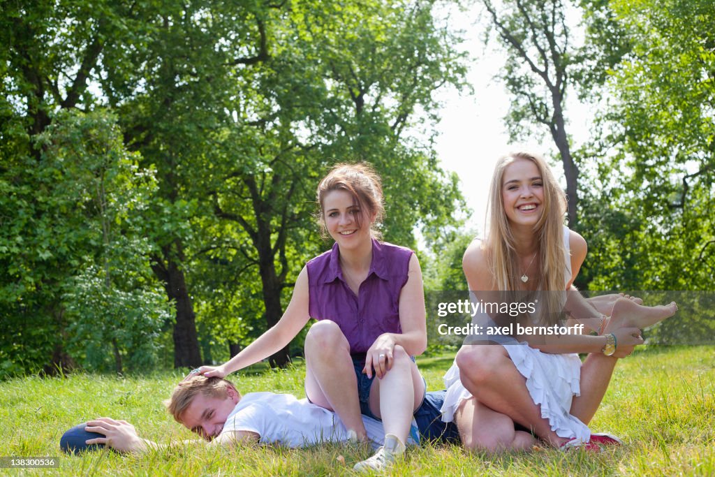 Teenagers playing in grass in park