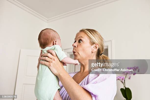 mutter holding baby im schlafzimmer - surprised mum stock-fotos und bilder