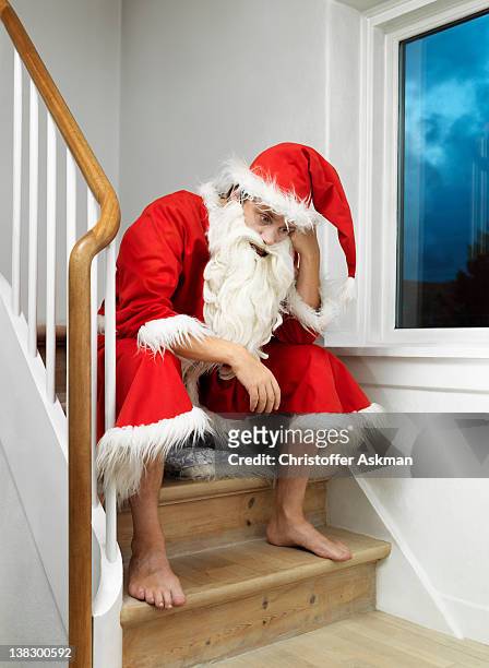man in santa claus suit sitting on steps - santa leaning stock pictures, royalty-free photos & images