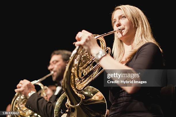 french horn players in orchestra - brass instrument stock pictures, royalty-free photos & images