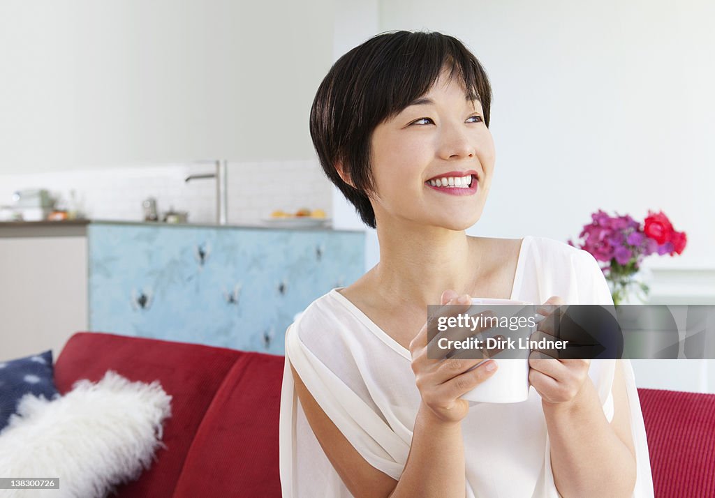 Smiling woman drinking cup of coffee