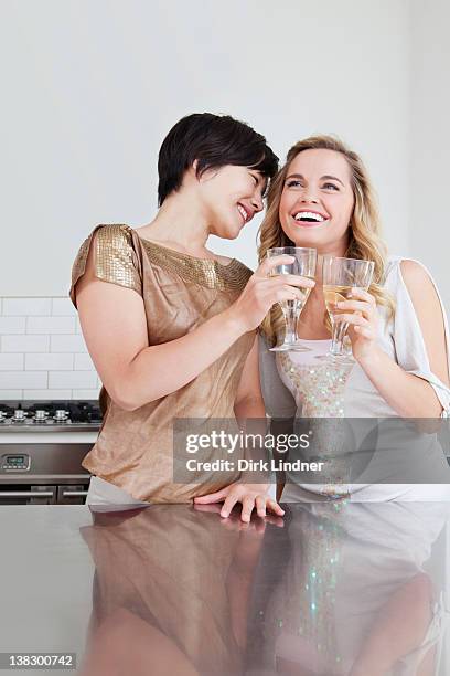 lachen frauen miteinander anstoßen - freundinnen wein stock-fotos und bilder