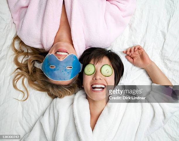 women in bathrobes wearing eye masks - indulgence stockfoto's en -beelden