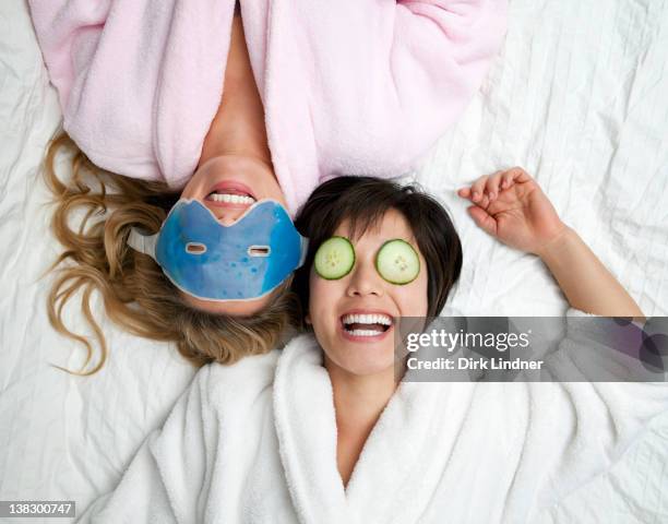 women in bathrobes wearing eye masks - cucumber eye mask stock pictures, royalty-free photos & images