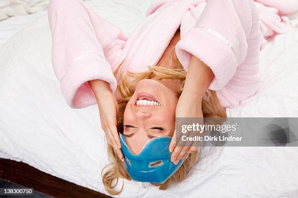 donna sul letto con maschera per gli occhi sulla fronte - eye mask foto e immagini stock