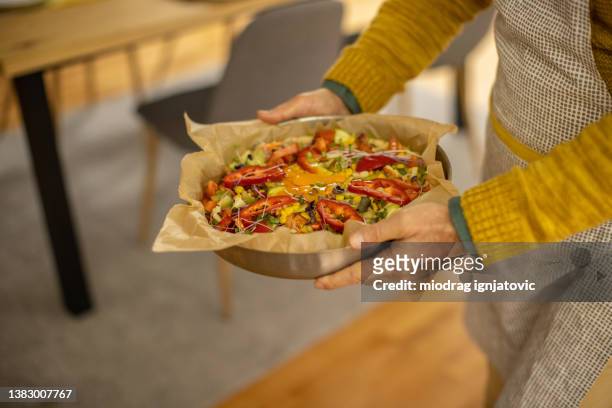 nicht wiederzuerkennender männlicher koch, der die backform mit hausgemachter pizza hält - gluten free stock-fotos und bilder