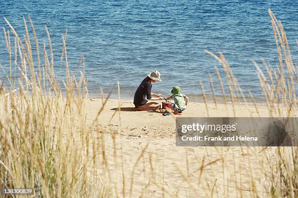 mother and child playing on beach - beach family stockfoto's en -beelden