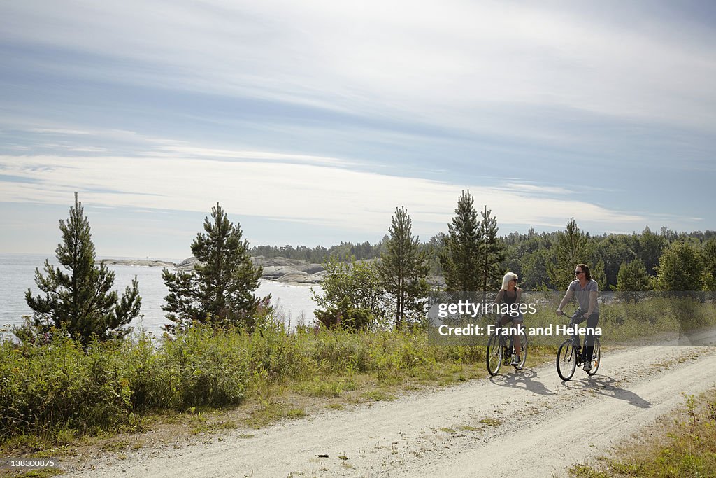 Couple bicycling on rural dirt path
