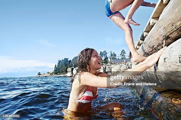 teenage girls climbing pier - lake scandinavia stock pictures, royalty-free photos & images