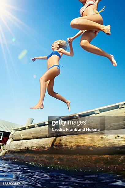 teenage girls jumping into lake - familie warm stock pictures, royalty-free photos & images