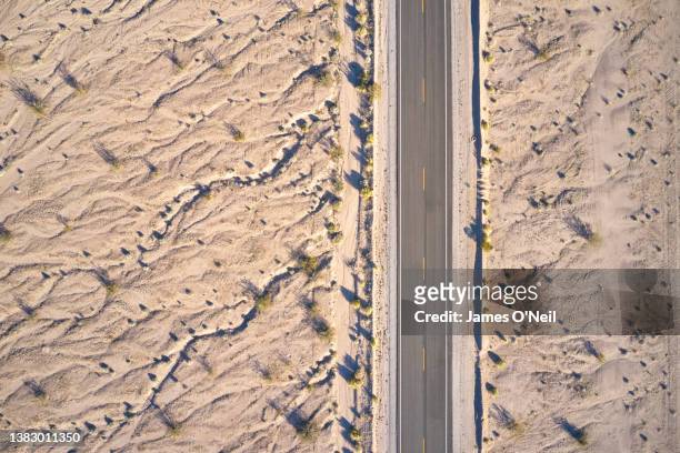 asphalt road through a desert landscape from above - wüstenstraße stock-fotos und bilder