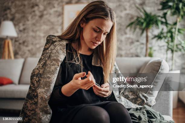 viuda llorando en casa porque su marido ha muerto en la guerra - funeral parlor fotografías e imágenes de stock