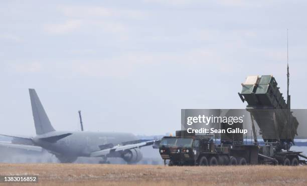 An Italian military transport plane lands on the runway as a U.S. Army MIM-104 Patriot anti-missile defence launcher stands pointing east at Rzeszow...